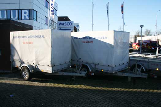 Twee witte bagageaanhangers geparkeerd bij Wasko
