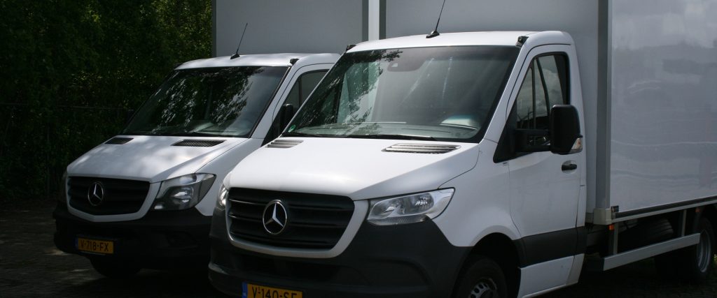 Twee witte Mercedes-Benz bestelwagens naast elkaar geparkeerd