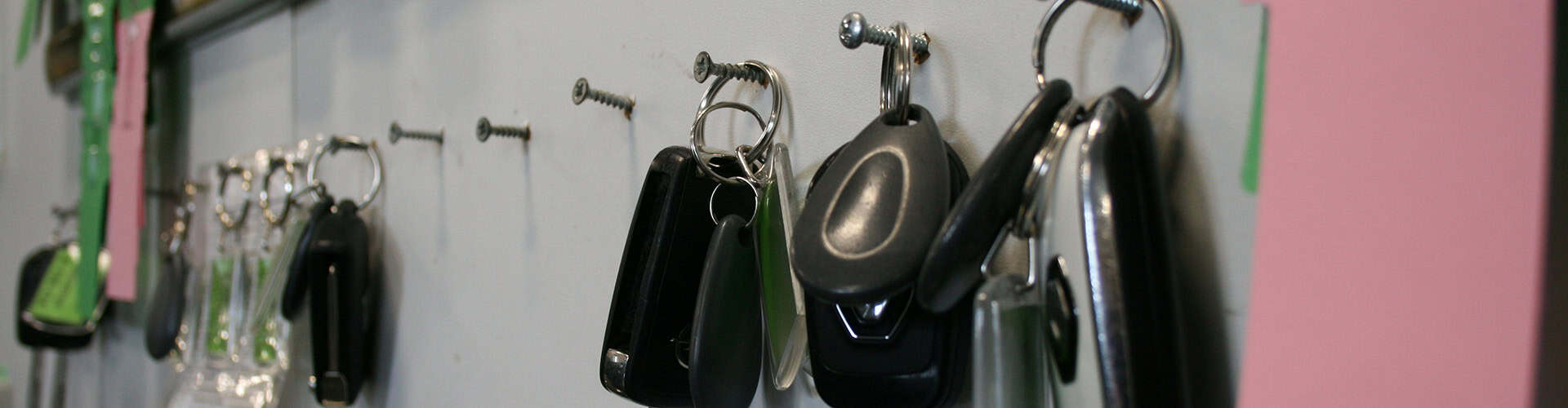 Autosleutels hangen aan haken op een wand