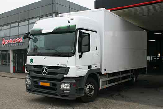 Witte Mercedes vrachtwagen voor bedrijfspand